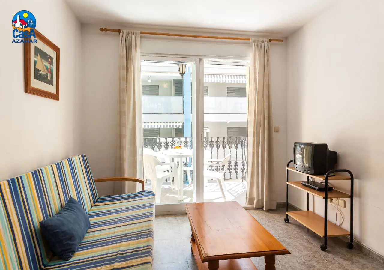 Salon avec canapé-lit et accès à la terrasse dans un appartement Mare Nostrum